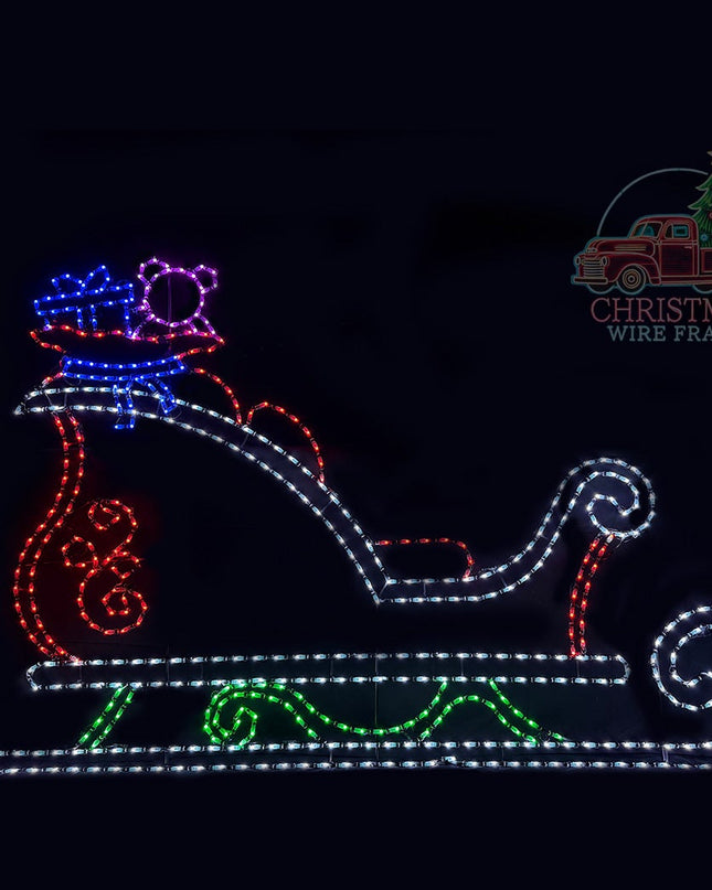 LED light display of a sleigh presents and teddy bear on a black background